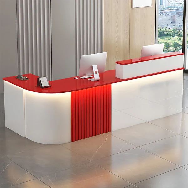 Modern red and white reception desk with monitors in an office lobby